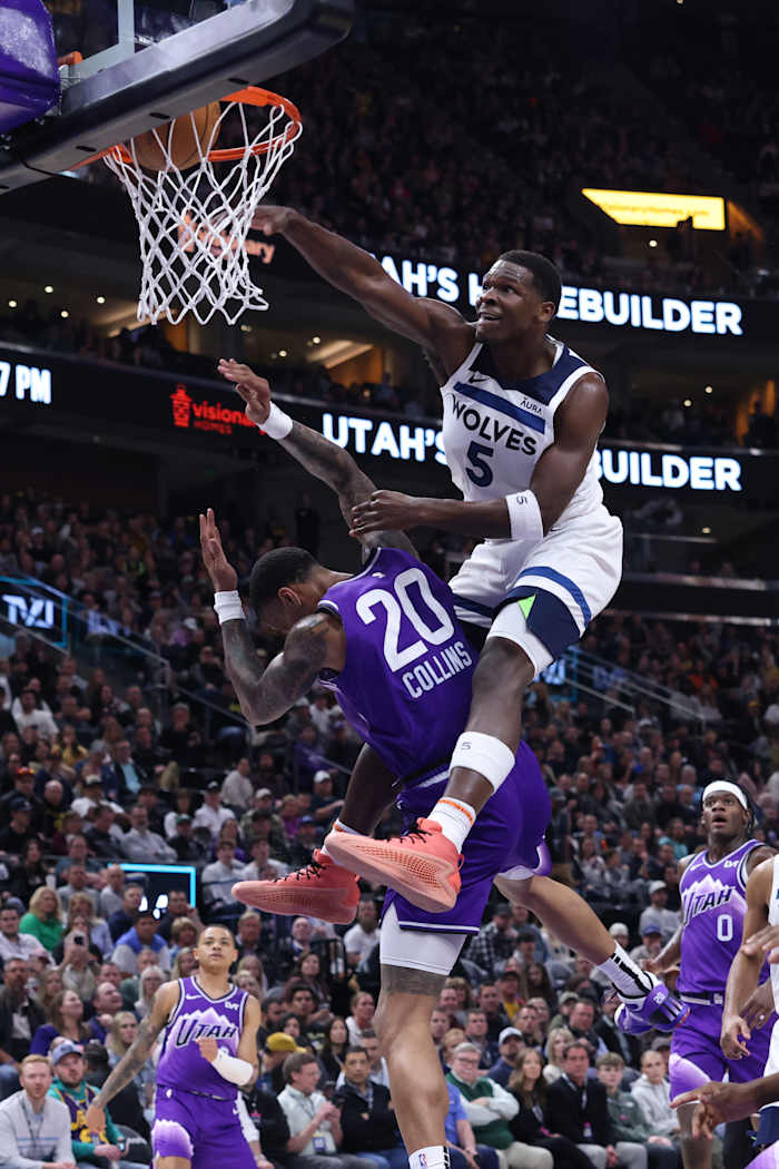 Minnesota Timberwolves guard Anthony Edwards dunks over Utah Jazz forward John Collins.